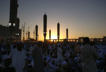people standing near high rise building during sunset