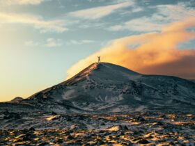 person standing on top of snow capped mountain during daytime