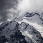 snow covered mountain under cloudy sky during daytime