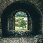 brown brick tunnel with green trees