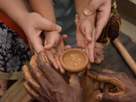 woman holding child's hand towards jar