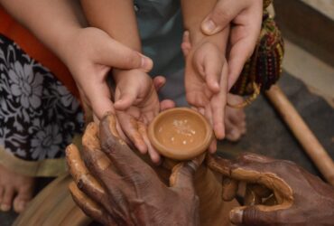woman holding child's hand towards jar