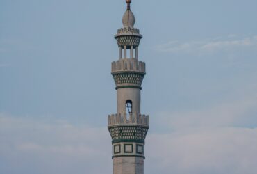 white concrete tower under white clouds during daytime