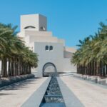 green palm trees near white concrete building during daytime