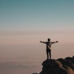 man standing beside cliff