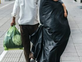 woman in black dress holding green plastic bag