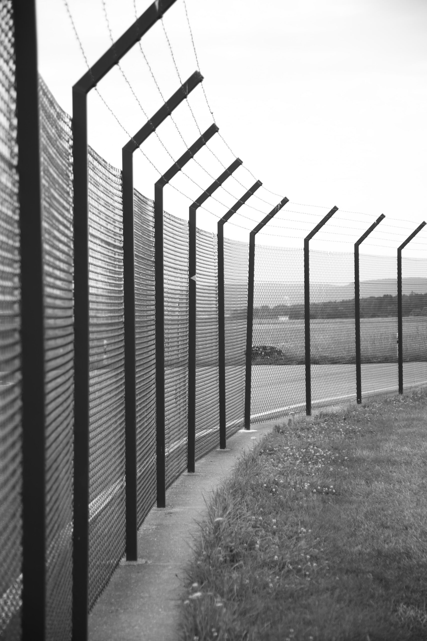 grayscale photo of metal fence