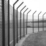 grayscale photo of metal fence