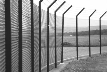 grayscale photo of metal fence