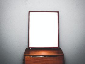 brown wooden dresser with mirror inside white room