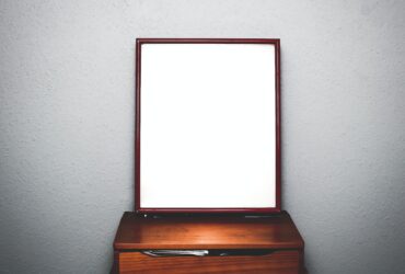 brown wooden dresser with mirror inside white room