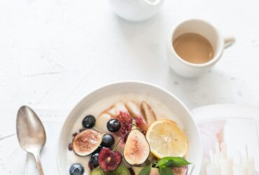 white ceramic plate beside gray steel spoon
