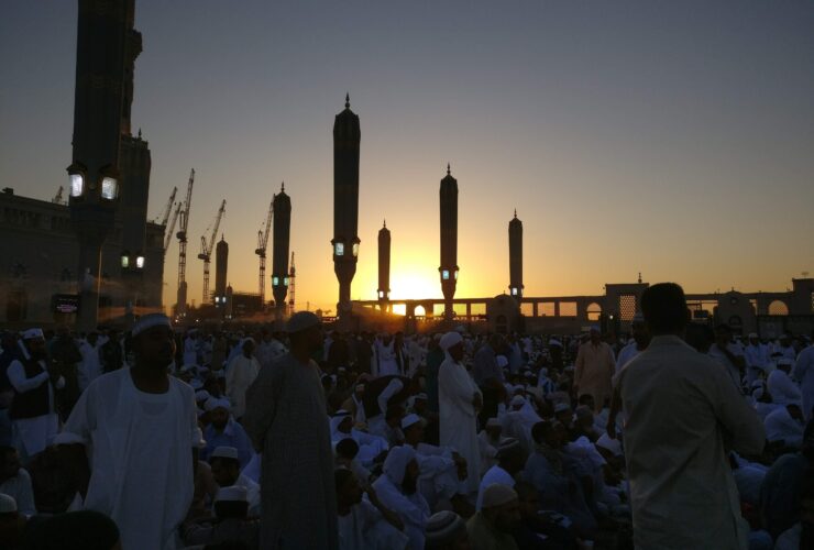 people standing near high rise building during sunset