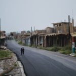 two persons walking on gray raod