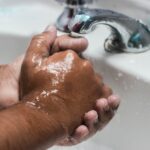 person washing hand on sink