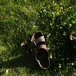 black and brown leather sandals on green grass
