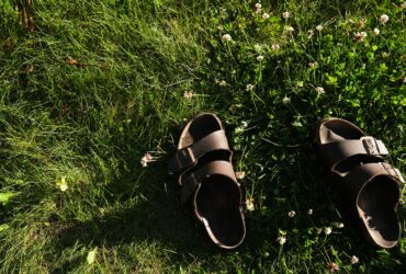 black and brown leather sandals on green grass