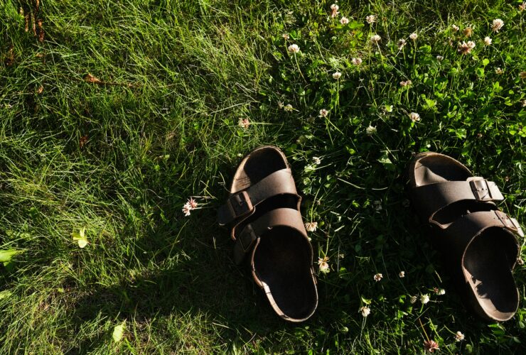 black and brown leather sandals on green grass