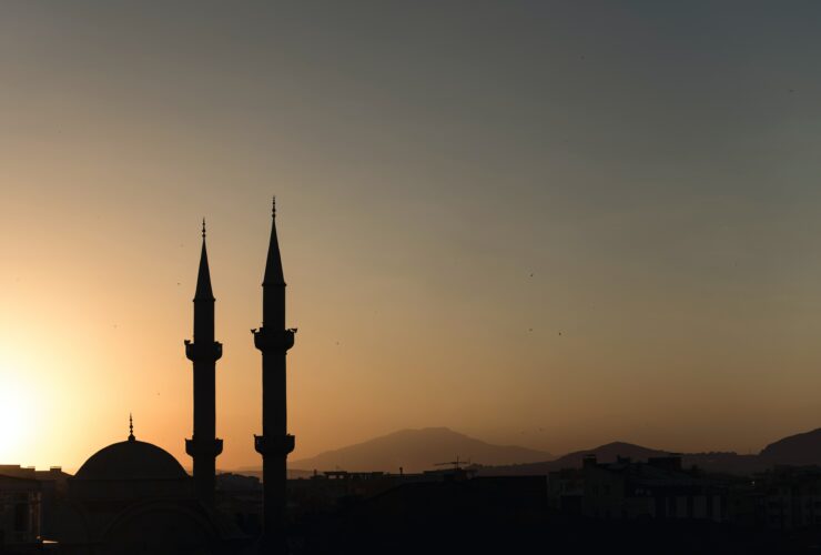 two mosque minarets under calm sky