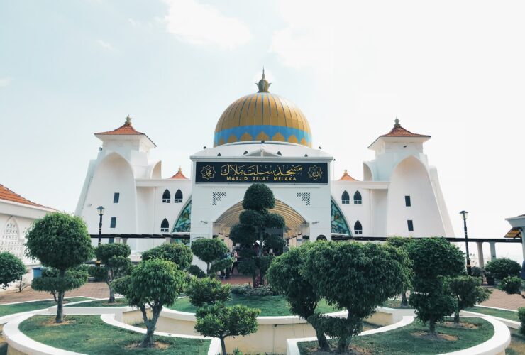trees in front of white and yellow mosque