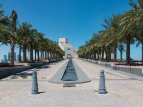 white concrete building near palm trees under blue sky during daytime