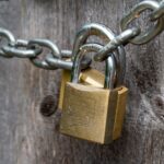 brown padlock on brown wooden fence