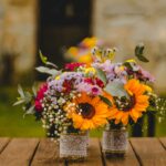 two bouquet of petaled flowers on brown wooden table