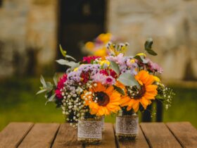 two bouquet of petaled flowers on brown wooden table