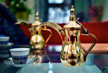 white and red floral ceramic teapot on table