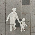 2 person walking on gray concrete pavement