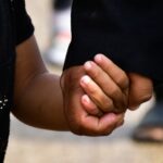person in black t-shirt holding persons hand