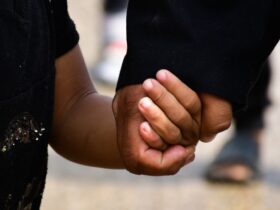 person in black t-shirt holding persons hand