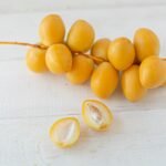 yellow round fruits on white wooden table