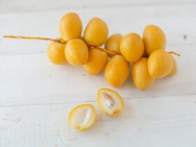 yellow round fruits on white wooden table
