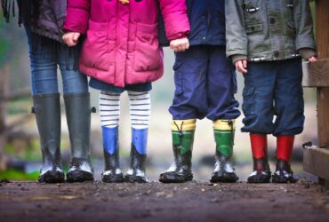 four children standing on dirt during daytime