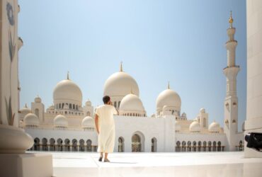 man standing near white mosque