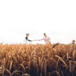 two persons standing on wheat field