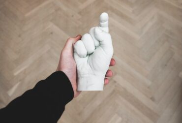 person hand holding hand figurine