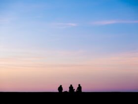 silhouette photography of three person sitting under sky