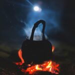 person in black hoodie standing on fire during nighttime