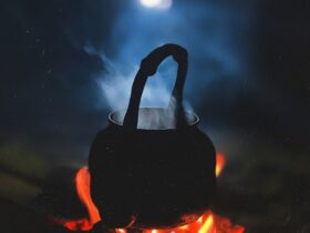 person in black hoodie standing on fire during nighttime