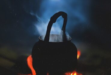 person in black hoodie standing on fire during nighttime