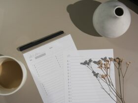 white printer paper beside white ceramic mug