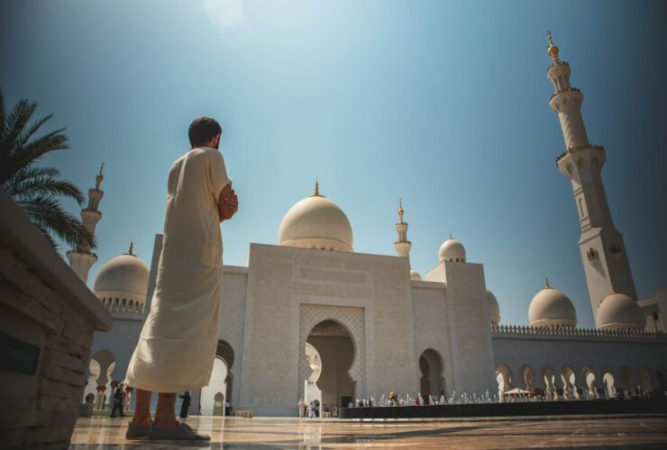 man standing near white mosque