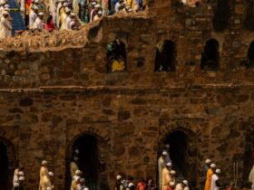 people in traditional dress standing on brown concrete building during daytime