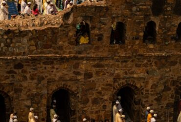 people in traditional dress standing on brown concrete building during daytime