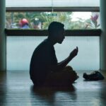 man in black shirt sitting on floor