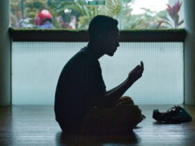 man in black shirt sitting on floor