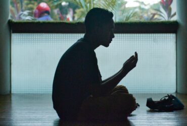 man in black shirt sitting on floor