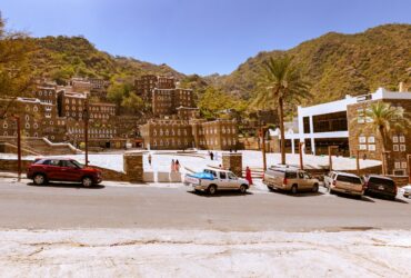 cars parked on side of the road near buildings during daytime